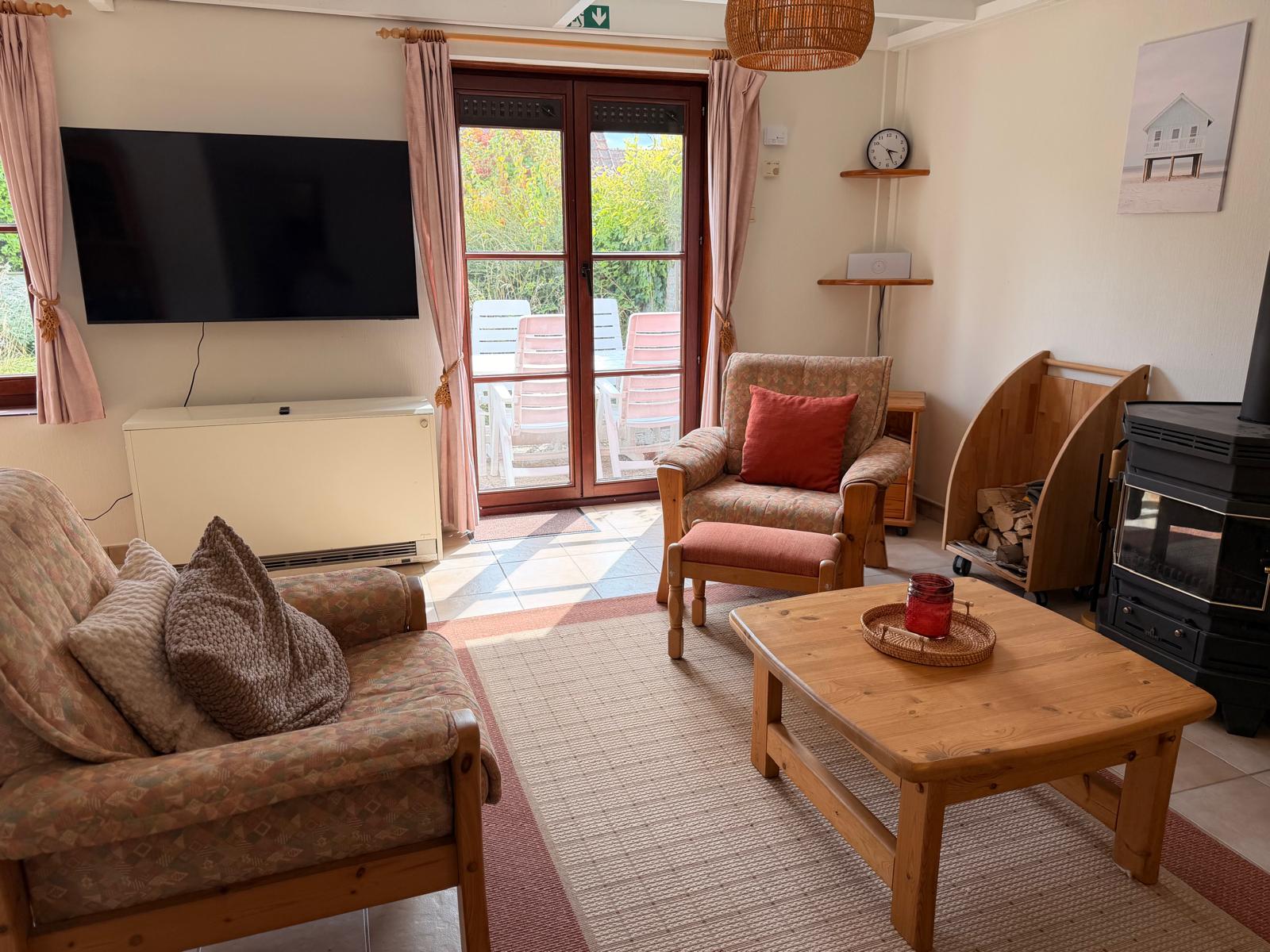Living room with sofas, TV and wood burner